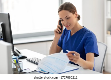 medicine, technology and healthcare concept - happy smiling female doctor or nurse with computer and clipboard calling on phone at hospital - Powered by Shutterstock