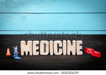MEDICINE. Text from concrete alphabet letters on a black wooden table.