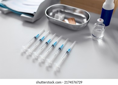 medicine, vaccination and healthcare concept - disposable syringes and other stuff on table at hospital