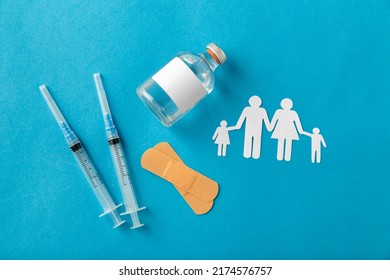 Arzneimittel, Impfung und Gesundheitskonzept - Einwegspritzen und Familienpiktogramm auf blauem Hintergrund
