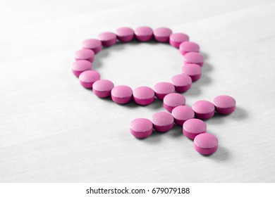 Medicine For Woman. Menopause, Pms, Menstruation Or Estrogen Concept. Female Health. Gender Symbol Made From Pink Red Pills Or Tablets On Wooden Table.