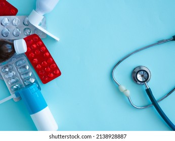 Medicines, Empty Pill Blisters, Potion Bottles, Inhaler And Medicinal Spray Bottles, Phonendoscope On Blue With Space For Text. Medicine Shortage Concept.