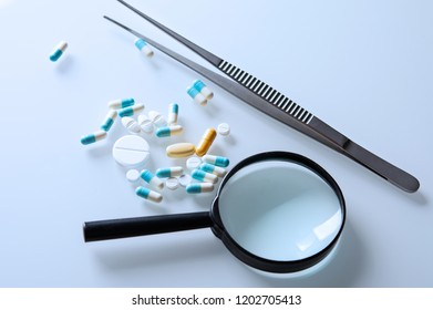 Medicines And Magnifying Glass With Tweezers On The Stele