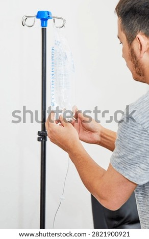 A Medic's hand setting up the Saline Solution in preparation for an IV Therapy Treatment