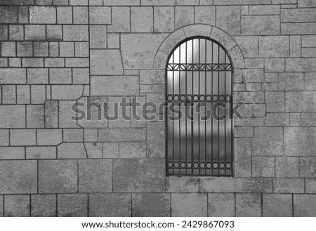 Medieval Arch Stone Blocks Castle Gate with Metal Lattice. black background. Stone wall with door protected by iron bars. wrought-iron gate at a decorative entrance to stone house.