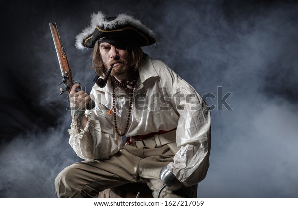 medieval bearded pirate with a sword and gun.\
concept photo of handsome man in a pirate vintage costume with\
pistol and saber
