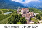 Medieval beautiful castles of northern Italy - splendid Thun castel amongst the apple trees of Val di Non. Trentino region, Trento province. Aerial drone panoramic view