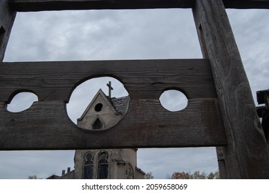 Medieval Block For Punishing Criminals Against The Background Of An Ancient Church. Medieval Execution Weapon