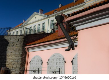 Medieval boot shape water pipe in Tallinn Old Town with orange-pink wall behind