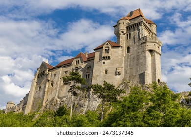 Medieval castle Burg Liechtenstein in Vienna, Austria. Ancient fortress with high stone walls in the middle of green grass meadow - Powered by Shutterstock