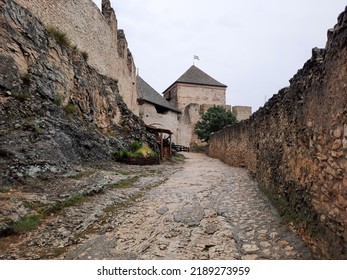 Medieval Castle Entrance With Tower And Ancient Stone Road