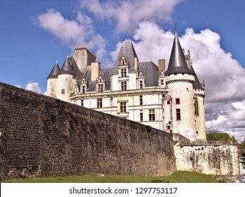 Medieval castle in France in a sunny summer afternoon with blue sky and some clouds.