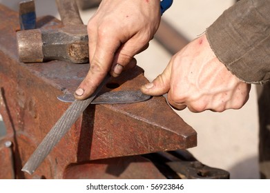 medieval craftsman blacksmith filing a piece of iron - Shutterstock ID 56923846