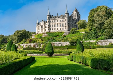 Medieval Dunrobin Castle on a hill and magnificent gardens at the foot of the castle, Scotland, UK.