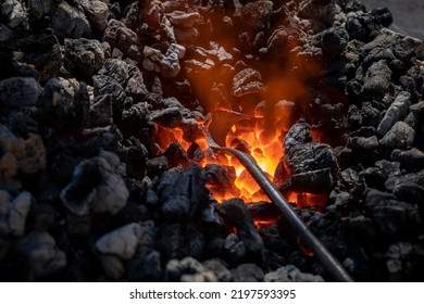 Medieval furnace with burning coal and an iron being heated so that after heating it can be worked - Powered by Shutterstock