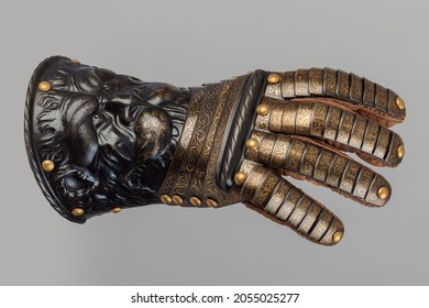Medieval knightly plate gauntlet from Italian armor, in the form of a lion's face and mane, period of the 16th century, on a light background.