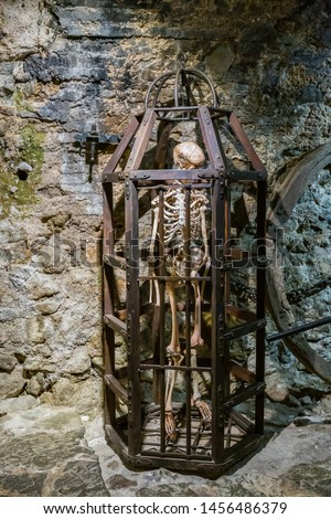 Medieval Metal cage with an old skeleton in the basement for torture