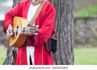 A medieval minstrel playing guitar during the annual 'Médiévales' festival in Luzarches, France.