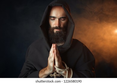 Medieval monk praying with closed eyes