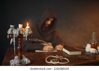 Medieval monk sitting at table and write, top view