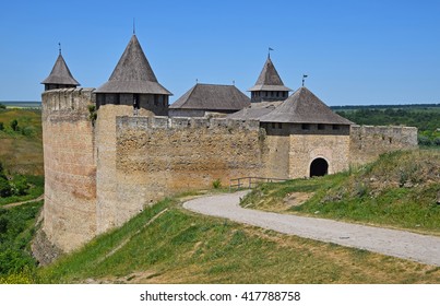 Medieval old fortress castle with ancient stone walls, wooden roofs and road, green hills and clear blue sky, Khotyn, Ukraine - Shutterstock ID 417788758