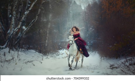 Medieval Queen on white horse at twilight winter forest 