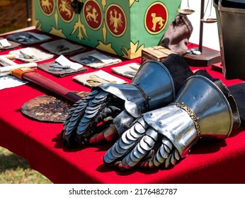 Medieval Reenactment - Gauntlets In Medieval Plates Laid On A Table With A Red Tablecloth