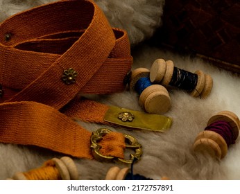 medieval reenactment objects, sewing set with spools of wool and a fabric belt on a fur