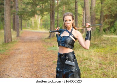 Medieval Robber Girl Wearing Leather Equipment With Falchion In Her Hands Defends The Path In The Forest