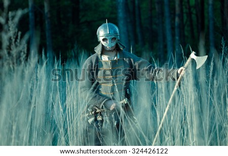 Medieval slav warrior man wearing in ancient armor with axe.
