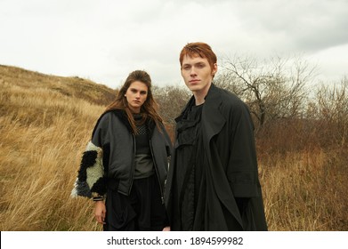 Medieval Style. Fashion. Male And Female. Two Young Models. Unusual Clothes. Nature Background. Red Hair, Freckles, Beautiful Faces. North. Siberia. Scandinavian Culture. Autumn. Yellow Field. Clouds