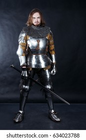 A Medieval Warrior With A Sword. Knight On Dark Background