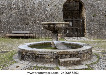 Medieval wellspring rustic design cobblestone piazza picturesque setting tourism attraction historic site tranquil scene Italian culture.