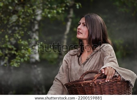 Medieval young poor woman in the forest