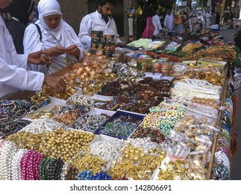 MEDINA, SAUDI ARABIA-JUNE 1: Unidentified woman buys fake jewelry in front of entrance of Nabawi Mosque in Medina on May 30, 2013. Estimated that 10% of its population are employed.