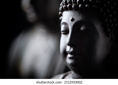 Meditating Buddha Statue on black background.	Close up. 