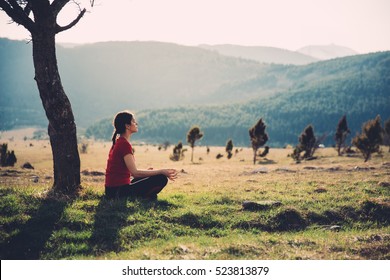 Meditating in nature on a sunny day. Finding inner peace. Practicing yoga. Well-being and healthy lifestyle concept.Enjoying peace and quiet,anti-stress therapy,mindfulness concept.