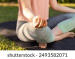 Meditating on yoga mat, person sitting cross-legged in outdoor setting. meditation, wellness, mindfulness, serenity, relaxation, nature