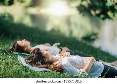 Meditation by the water. Two young women lying by the water and meditating - Shutterstock ID 1855735816