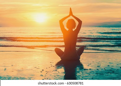 Meditation girl on the sea during sunset. Yoga silhouette.  - Shutterstock ID 630508781