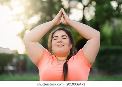 Meditation harmony. Body positive. Yoga outdoor. Mind freedom. Relaxed joyful overweight obese woman doing upward salute in defocused nature landscape.