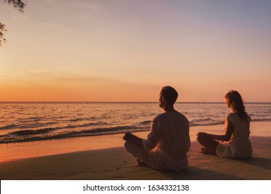 meditation and relaxation for couple, yoga group on the beach at sunset - Powered by Shutterstock