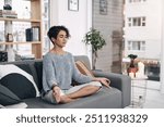 Meditation teaches you that life is not supposed to hurt. Shot of an attractive young woman meditating on a sofa at home.