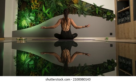 Meditation, yoga and fitness, healthy lifestyle. Beautiful yoga woman and her reflection, candlelight and exotic place