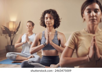 Meditation, yoga group and women in gym for peace, mindfulness and spiritual wellness with chakra balance. Pilates girls, health class and lotus pose for zen soul and prayer hands for healing aura - Powered by Shutterstock