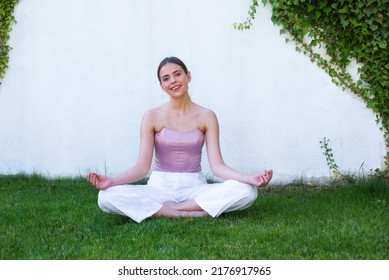 Meditation Yoga Woman In Spring Park. Yoga Woman Stretching With Pose Stretch. Fit Fitness Athlete Girl Exercising Sports Stretches. Outdoor Workout On Green Grass.