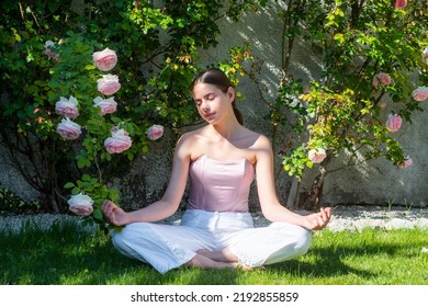 Meditation Yoga Woman In Spring Park On Green Grass. Fitness Sport Woman Stretching Out Before Training. Female Fit Model. Stretching And Motivation. Outdoor Workout.