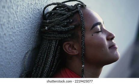 Meditative Young Woman Eyes Closed Relaxing Outside. A Pensive Hispanic Black Brazilian With Restul Peace Of Mind