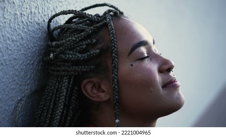 Meditative Young Woman Eyes Closed Relaxing Outside. A Pensive Hispanic Black Brazilian With Restul Peace Of Mind