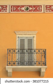 Mediterranean House Facade With Balcony, Closed Shutters And Ornamental Stucco Border